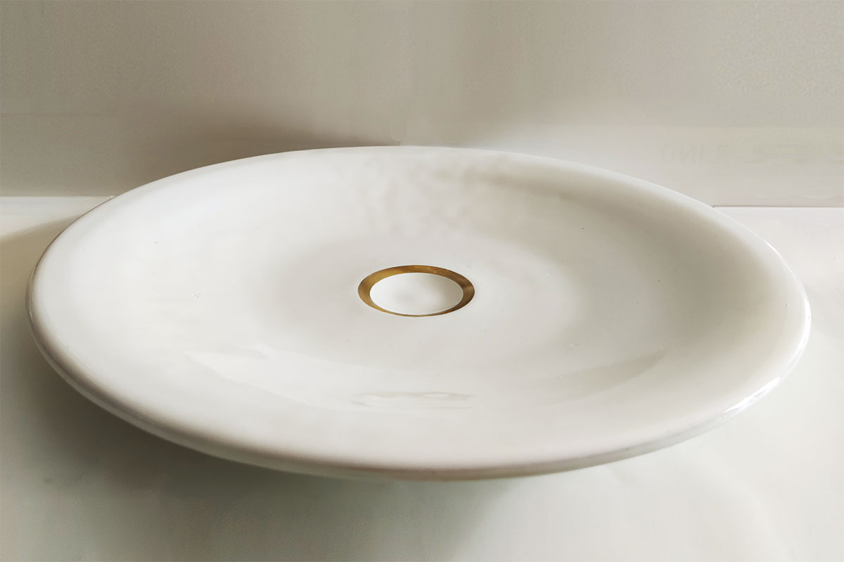 piatto in ceramica bianca con segno grafico oro